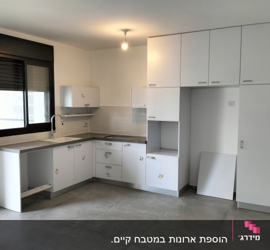 מטבח חדש עם ארונות לבנים ומשטח עבודה אפור